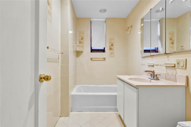 bathroom featuring tile walls, vanity, tiled shower / bath combo, and tile patterned floors