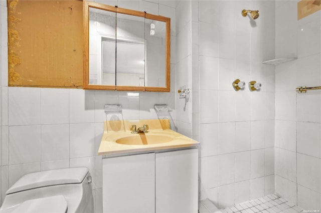 bathroom featuring vanity, tile walls, and toilet