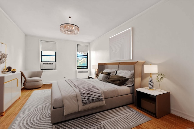 bedroom featuring crown molding, a notable chandelier, and light hardwood / wood-style flooring