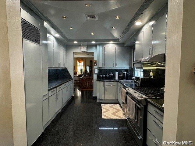 kitchen featuring decorative backsplash, electric range, and crown molding