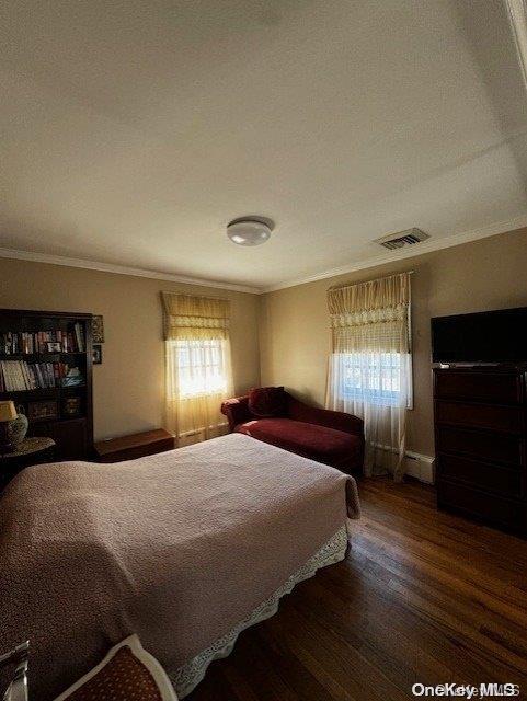 bedroom featuring dark hardwood / wood-style floors and ornamental molding