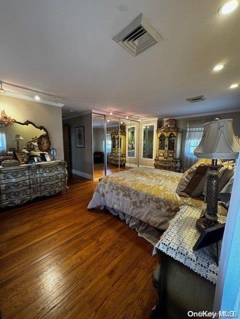 bedroom featuring dark hardwood / wood-style flooring and ornamental molding