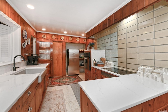 kitchen featuring wood walls, sink, ornamental molding, tasteful backsplash, and stainless steel appliances