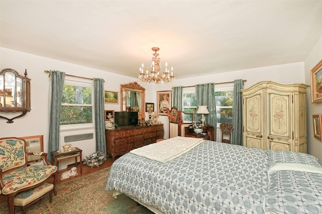 bedroom with hardwood / wood-style floors, multiple windows, and a notable chandelier