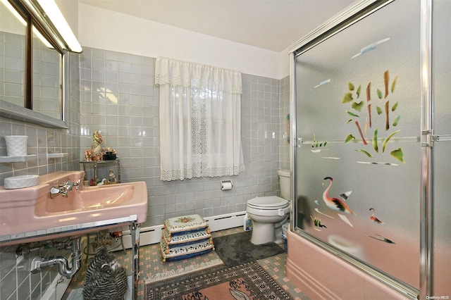 full bathroom featuring vanity, shower / bath combination with glass door, tile patterned flooring, toilet, and tile walls