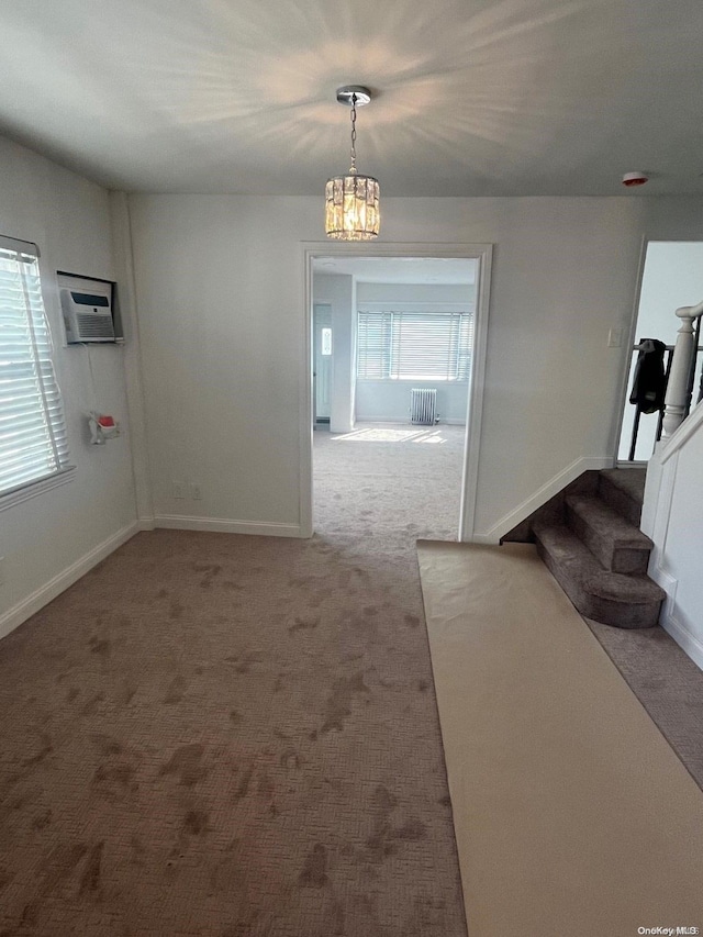 interior space with a notable chandelier, plenty of natural light, radiator, and a wall mounted AC