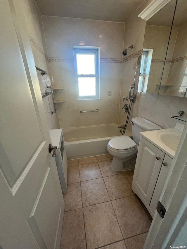 full bathroom with vanity, tile patterned floors, tiled shower / bath combo, toilet, and radiator heating unit