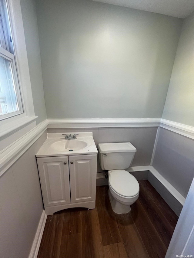 bathroom with hardwood / wood-style floors, vanity, and toilet