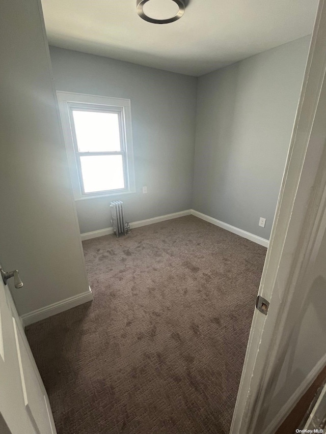 empty room featuring carpet floors and radiator