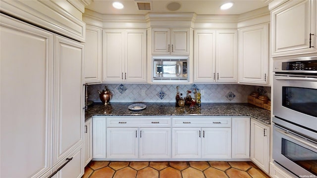 267 Great River Rd, Great River, NY 11739 - kitchen featuring built in appliances, light tile patterned floors, and white cabinetry