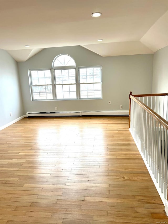 empty room with light hardwood / wood-style flooring, a wealth of natural light, and vaulted ceiling