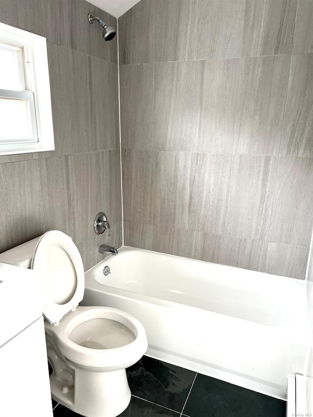 full bathroom featuring vanity, tiled shower / bath, and toilet