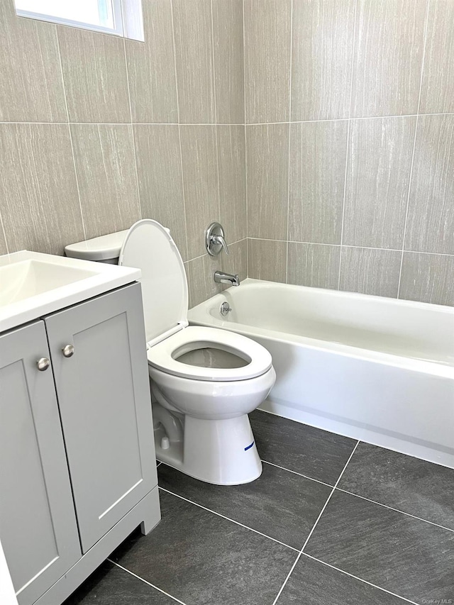 full bathroom featuring tiled shower / bath, tile patterned floors, toilet, and vanity