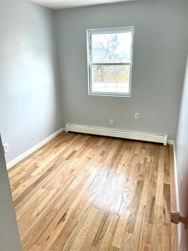 empty room featuring light hardwood / wood-style floors and baseboard heating