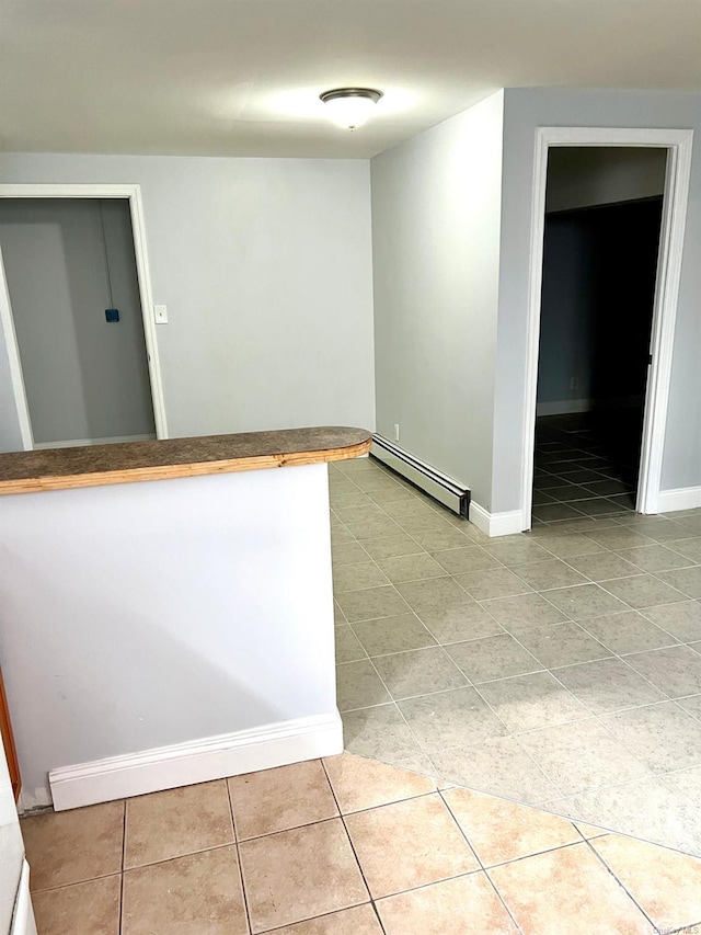 unfurnished room featuring a baseboard radiator and light tile patterned flooring