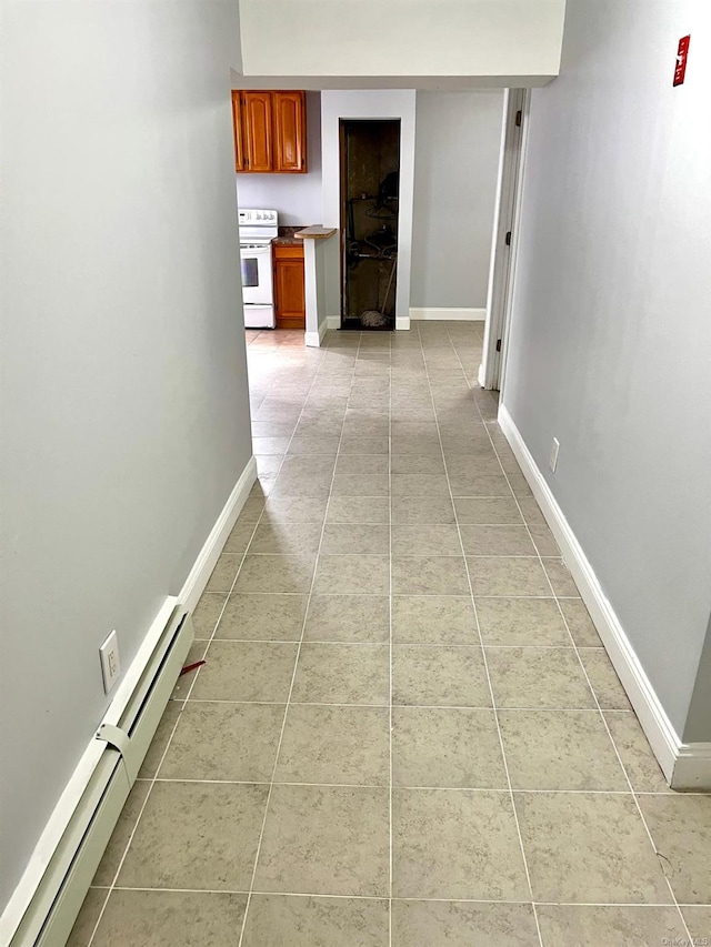 hallway featuring baseboard heating and light tile patterned flooring