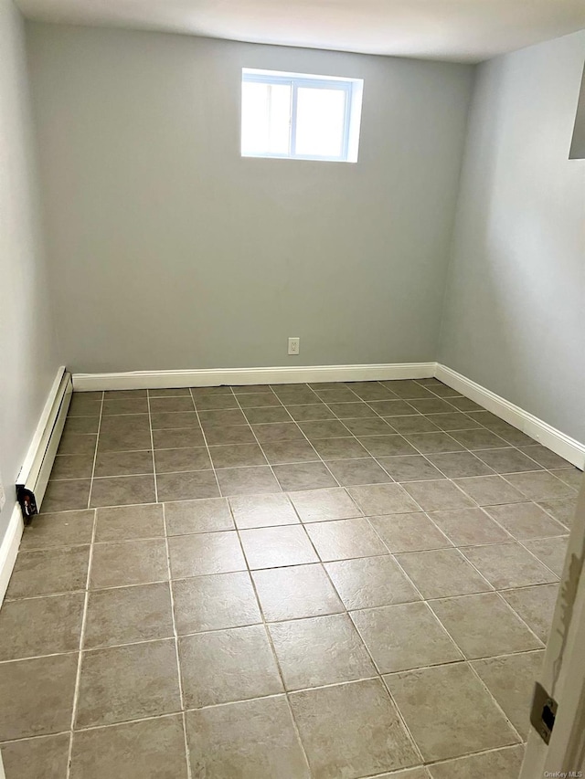 spare room featuring a baseboard heating unit and tile patterned floors