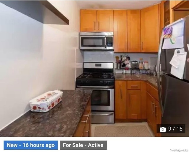 kitchen with backsplash, dark stone countertops, and appliances with stainless steel finishes