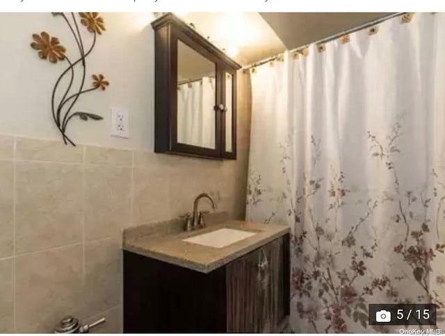 bathroom with vanity and tile walls