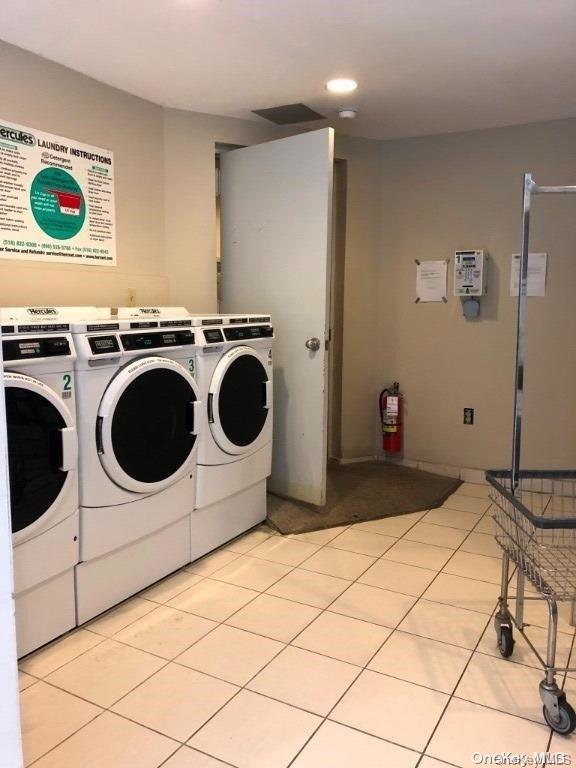 laundry area featuring washing machine and dryer and light tile patterned flooring