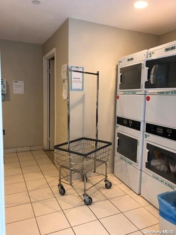 interior space with light tile patterned floors, washing machine and dryer, and stacked washer and clothes dryer