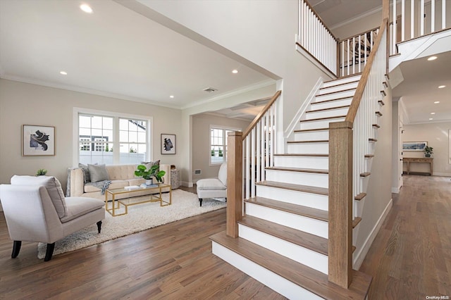 stairs with hardwood / wood-style floors and ornamental molding