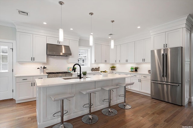 kitchen with pendant lighting, stainless steel refrigerator, a wealth of natural light, and sink