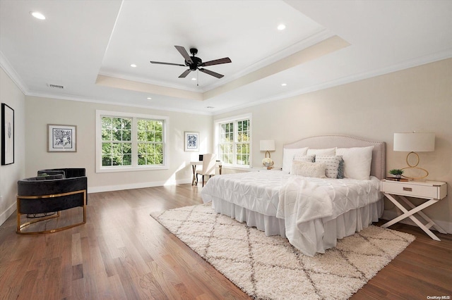 bedroom featuring a tray ceiling, ceiling fan, wood-type flooring, and ornamental molding