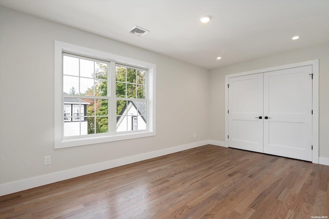 unfurnished bedroom featuring a closet and hardwood / wood-style flooring