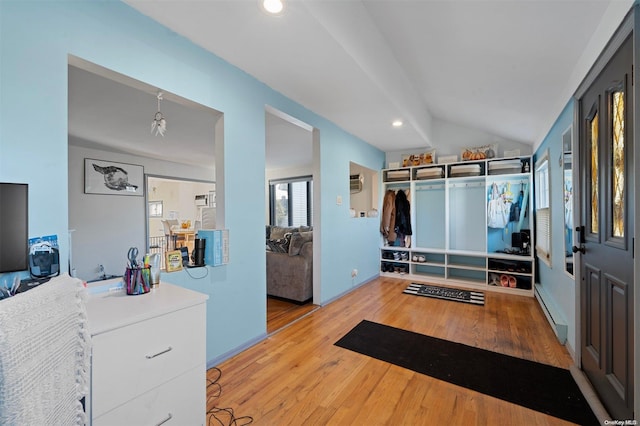 interior space featuring light hardwood / wood-style floors, vaulted ceiling, and baseboard heating