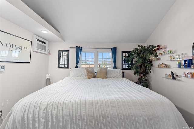 bedroom featuring a wall unit AC and lofted ceiling