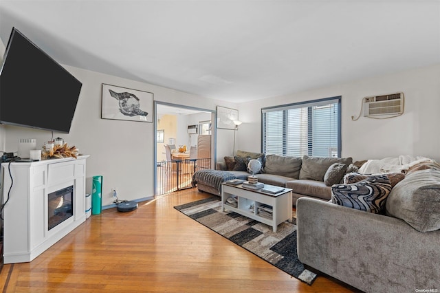 living room featuring light hardwood / wood-style floors and an AC wall unit