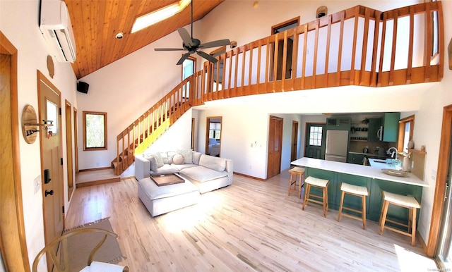 25 5th, Fair Harbor, NY 11706 - living area with a wall unit AC, high vaulted ceiling, stairs, light wood-style floors, and a ceiling fan