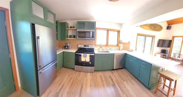 25 5th, Fair Harbor, NY 11706 - kitchen featuring appliances with stainless steel finishes, a peninsula, green cabinets, and plenty of natural light