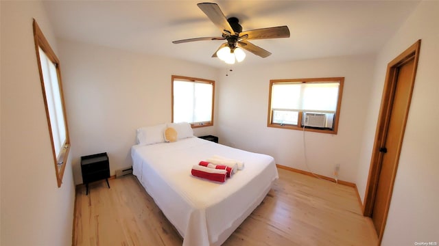 25 5th, Fair Harbor, NY 11706 - bedroom with light wood-style floors, cooling unit, baseboard heating, and ceiling fan