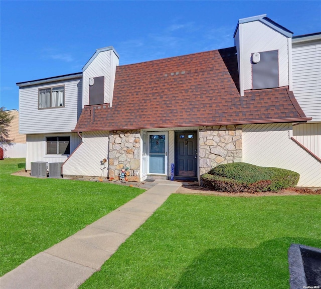 view of front of property with central AC unit and a front yard