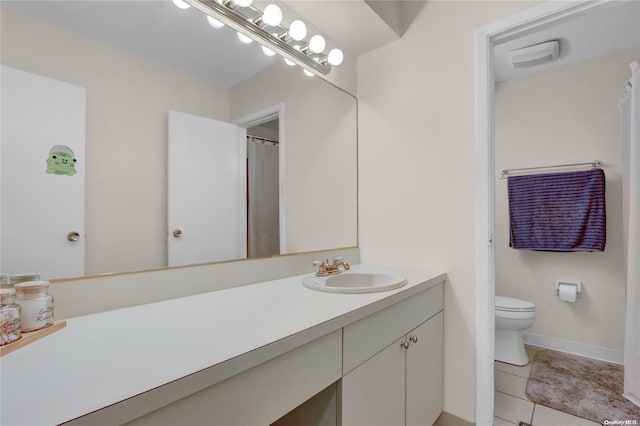 bathroom featuring toilet, vanity, and tile patterned floors