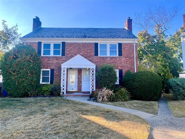 colonial home featuring a front lawn