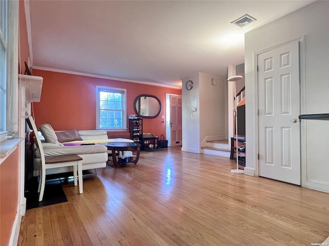 living room featuring light wood-type flooring and crown molding