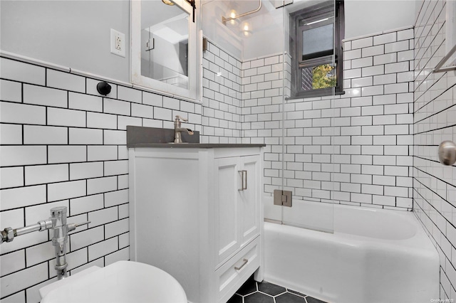 full bathroom featuring vanity, tiled shower / bath combo, tile walls, tile patterned flooring, and toilet