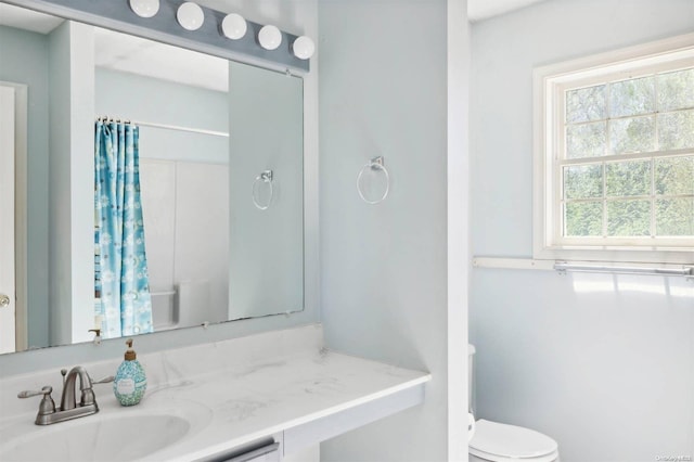 bathroom featuring vanity, toilet, and walk in shower