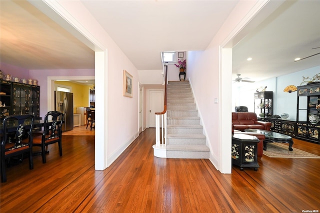 staircase featuring hardwood / wood-style flooring and ceiling fan