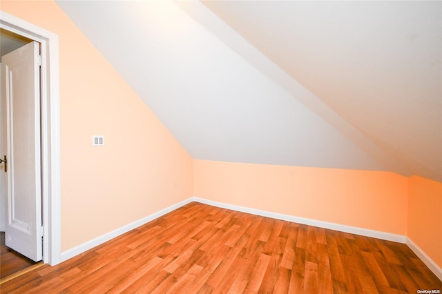 additional living space featuring hardwood / wood-style flooring and vaulted ceiling