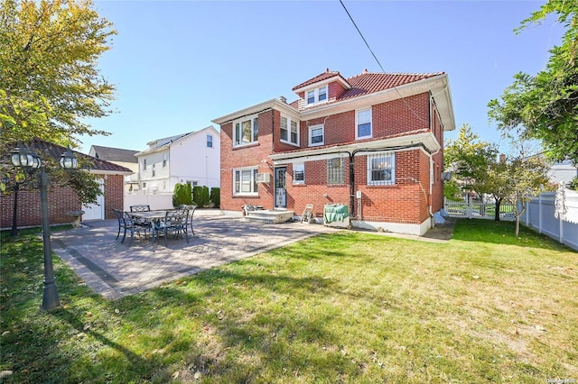 back of property with a lawn and a patio