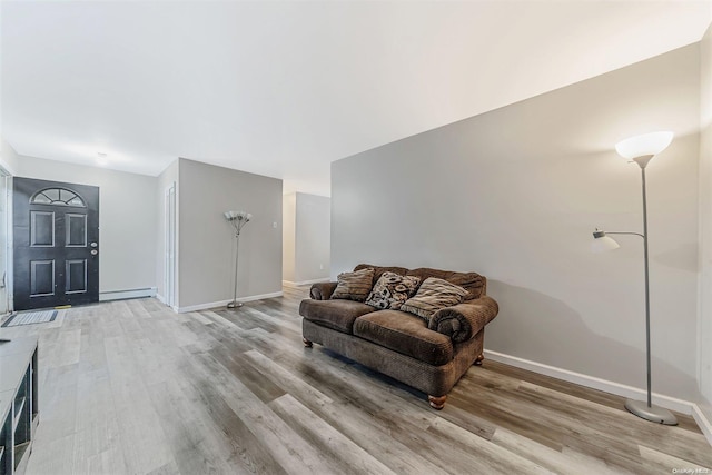 living room with light hardwood / wood-style floors and a baseboard heating unit