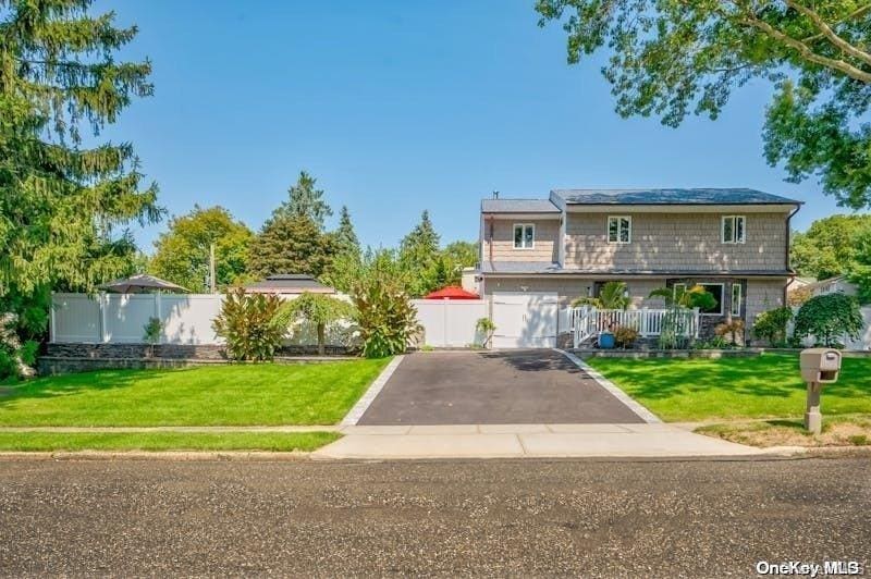 view of front of property featuring a front lawn and a garage