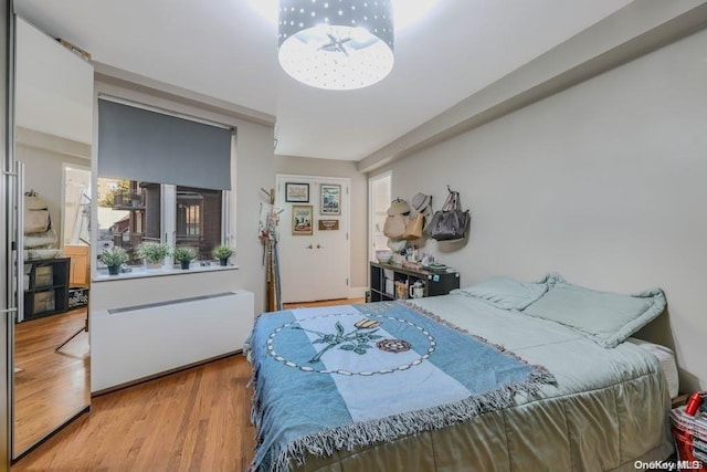 bedroom featuring light wood-type flooring and radiator