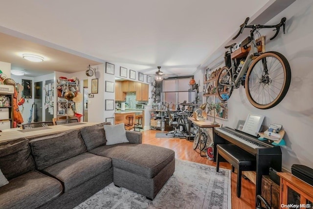 living room with ceiling fan and light hardwood / wood-style floors