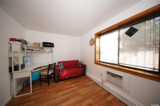 bedroom featuring a baseboard radiator, light hardwood / wood-style flooring, and a wall unit AC