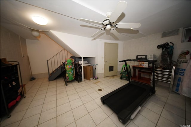 workout area featuring ceiling fan and light tile patterned floors